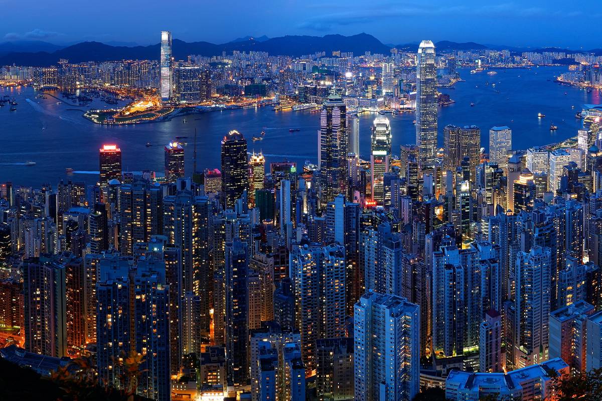 Upplysta skyskrapor och Victoria Harbour i skymningen sedda från Victoria Peak i Hongkong