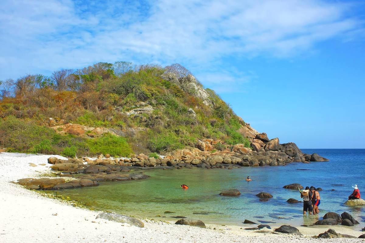 Vit sandstrand med klippor och klart turkost vatten på Pigeon Island utanför Trincomalee